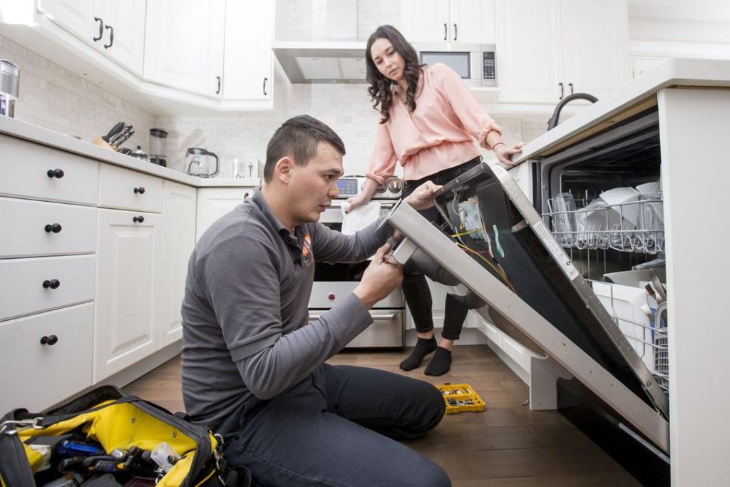 Image of home owner looking at dishwasher and wonder if repairs are covered by New Home Warranty. Don't confuse the new home warranty with your builder, equipment, or manufacturer's warranty.